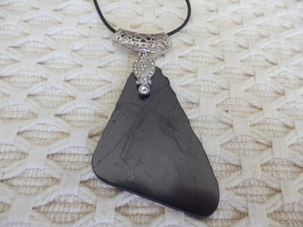 A black pendent with silver locket on it