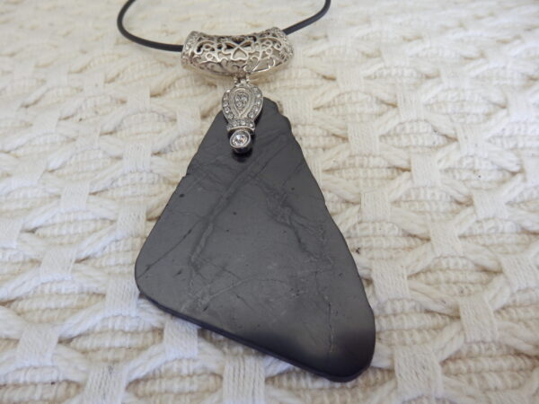 a black stone necklace with a silver pendant